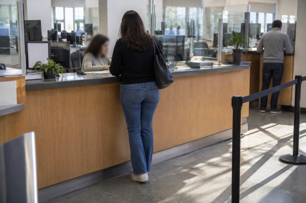 A records counter in a public office with a clerk helping a visitor