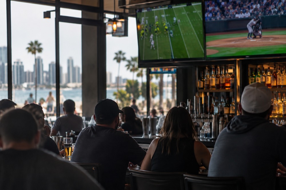 Sports bar interior with large screens above the counter