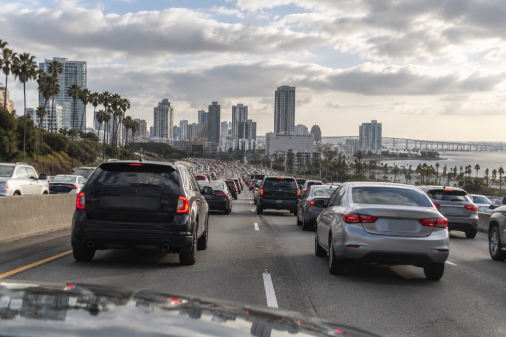 Heavy traffic on a multi-lane freeway with brake lights stretching into the distance