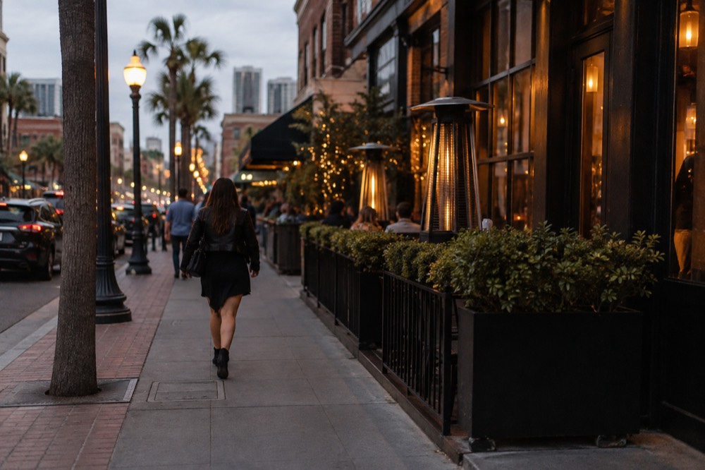 Evening sidewalk outside an upscale Gaslamp Quarter restaurant with warm light on the storefront
