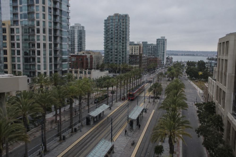 Light rail transit center with palm trees and mall signage in the background
