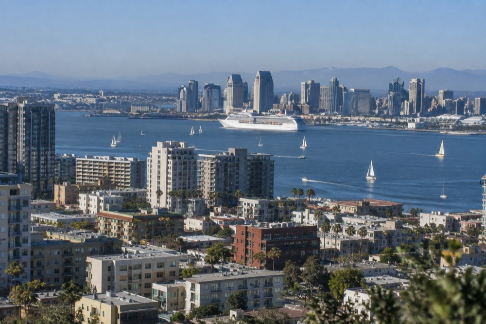 Sailboats and a cruise ship on San Diego Bay with the downtown skyline behind