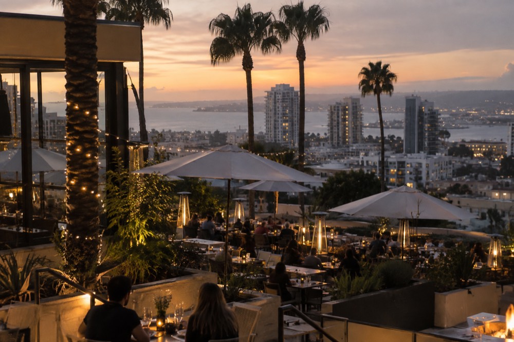Patio dining at dusk in a San Diego neighborhood with palm trees overhead