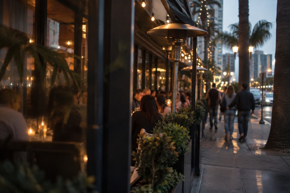 Busy restaurant row on a San Diego street at night with lit signage