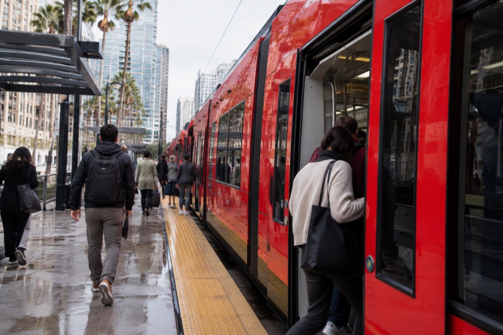 Trolley station platform with shoppers boarding a downtown San Diego trolley