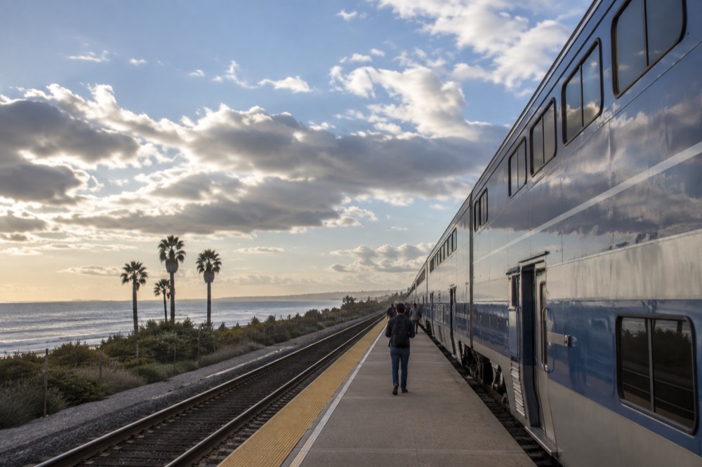 Commuter train at a small coastal station platform in the afternoon