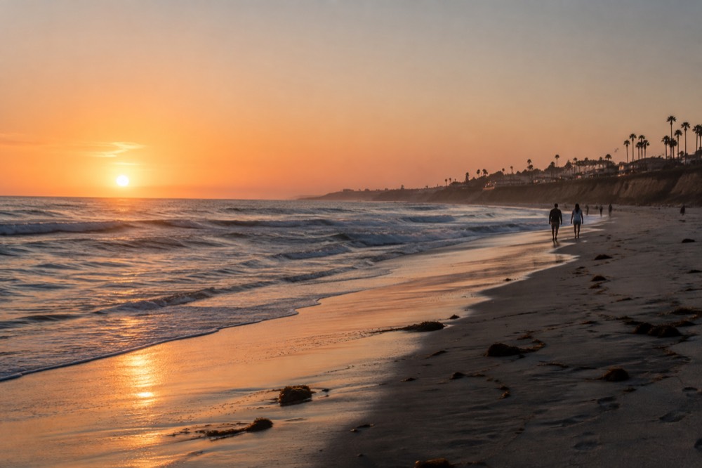 Coastal town beach at golden hour with soft light on the water
