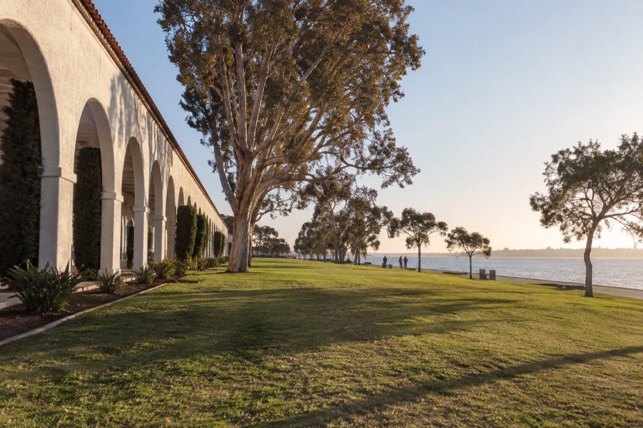Waterfront lawns and low historic buildings beside the bay at Liberty Station
