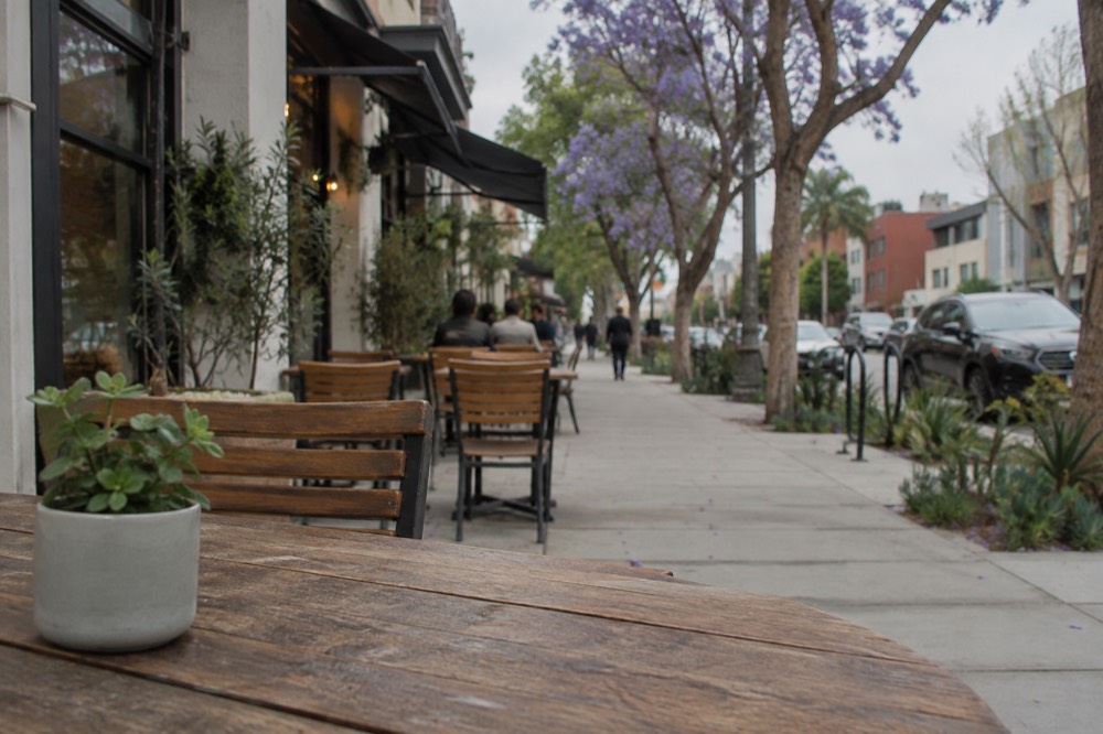Quiet city street with cafe tables in warm late afternoon light