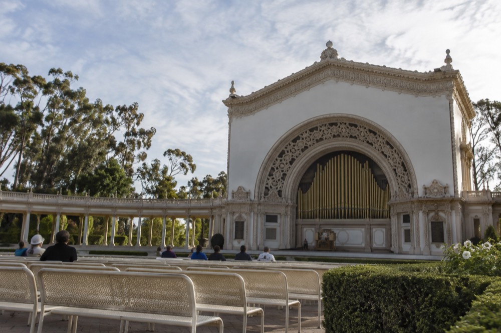 Outdoor pipe organ pavilion with rows of seats and garden landscaping