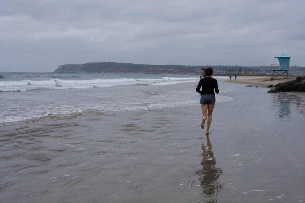 Gentle shallow water over rippled sand with a lifeguard tower in the background