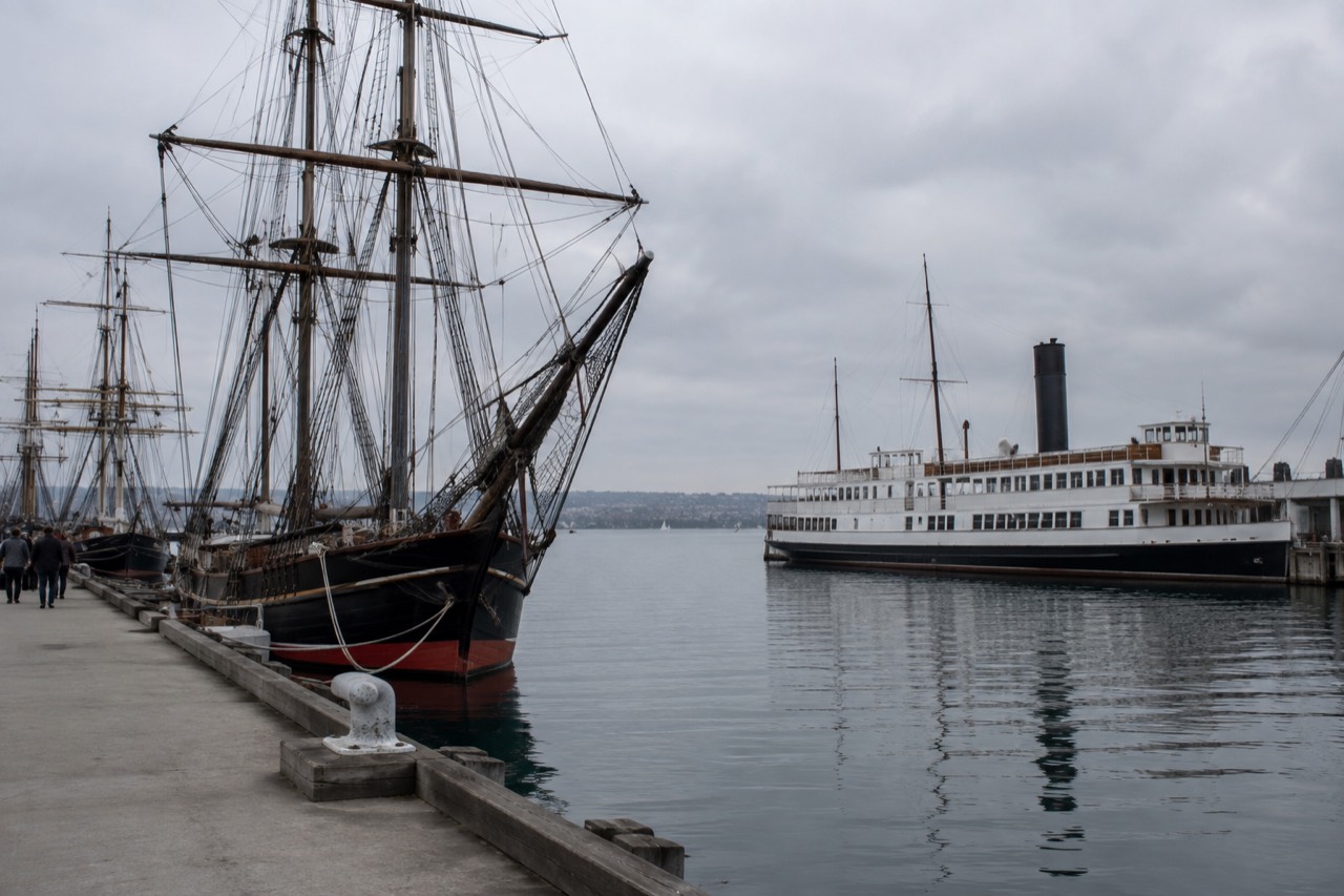 Historic tall ships and a steam ferry moored along the San Diego Embarcadero waterfront