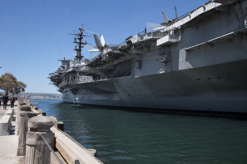 Waterfront path with the aircraft carrier museum ship moored across the bay
