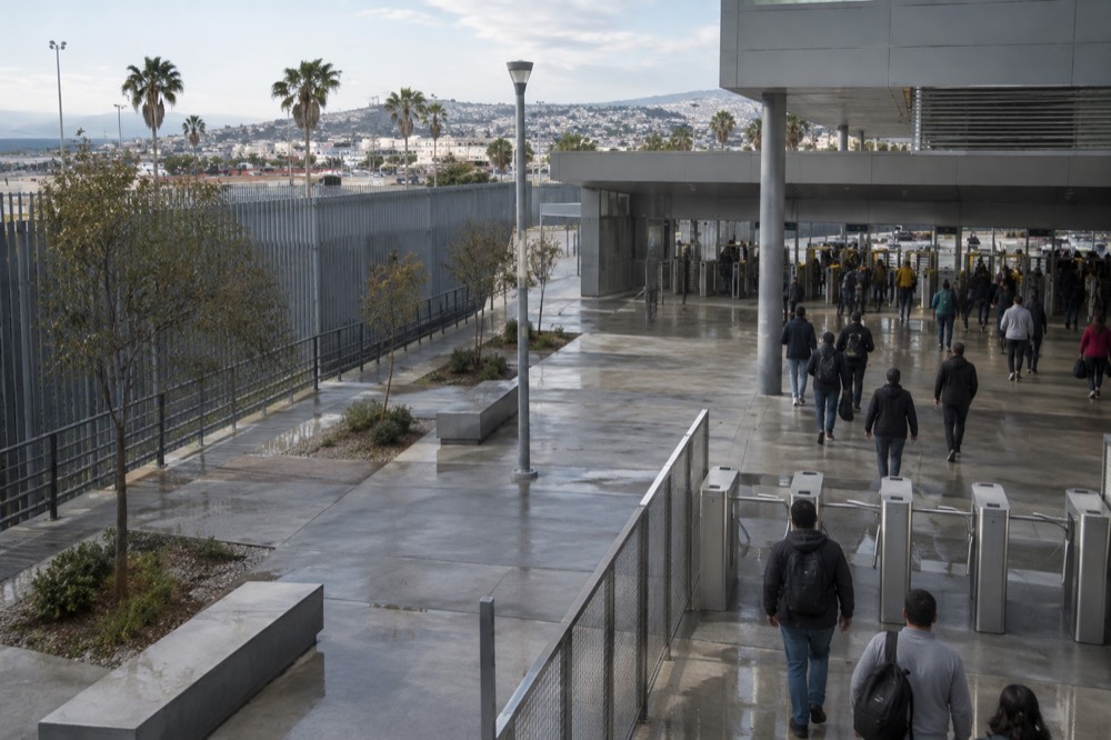 Pedestrian border crossing plaza with turnstiles and signage at an international port of entry
