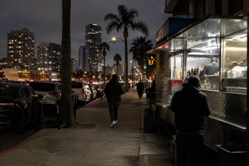 A late-night taco stand window lit up against a dark street