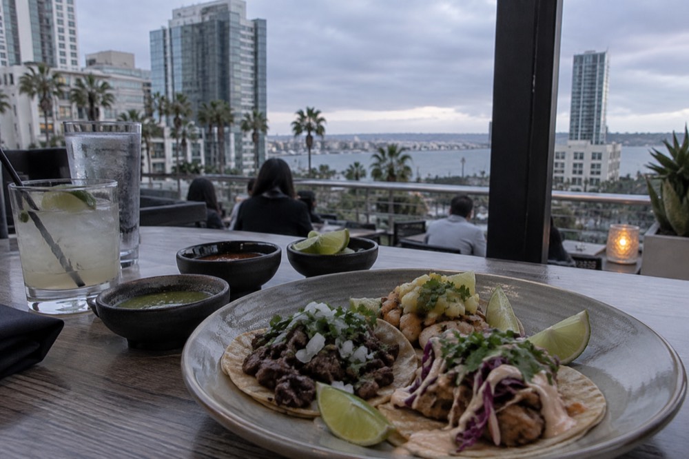 A plate of assorted tacos with salsas and lime on a restaurant table