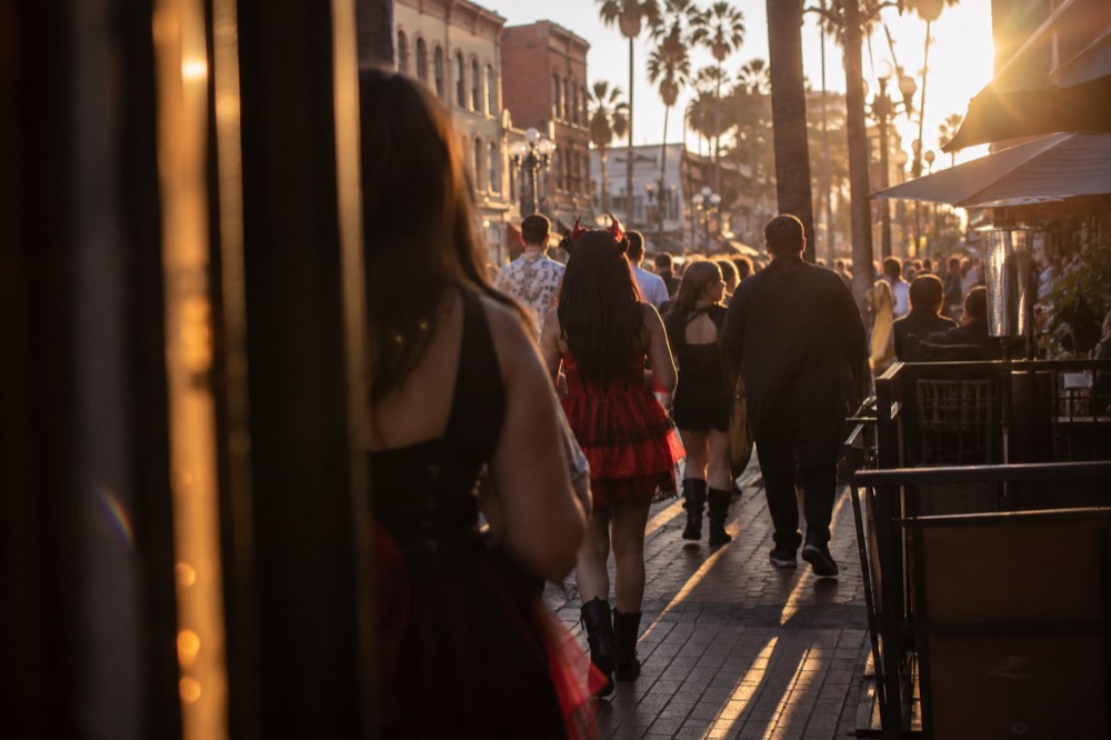 Crowded city sidewalks in the Gaslamp Quarter with costumed attendees walking between buildings
