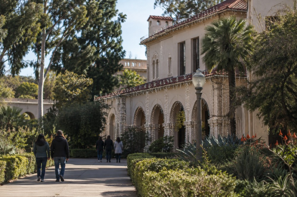 A museum building with Spanish colonial architecture decorated with white holiday lights