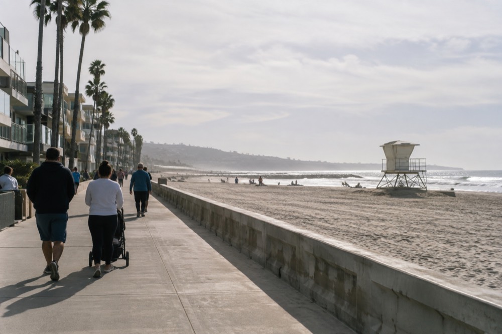 Beach boardwalk with a lifeguard tower and families walking beside the sand