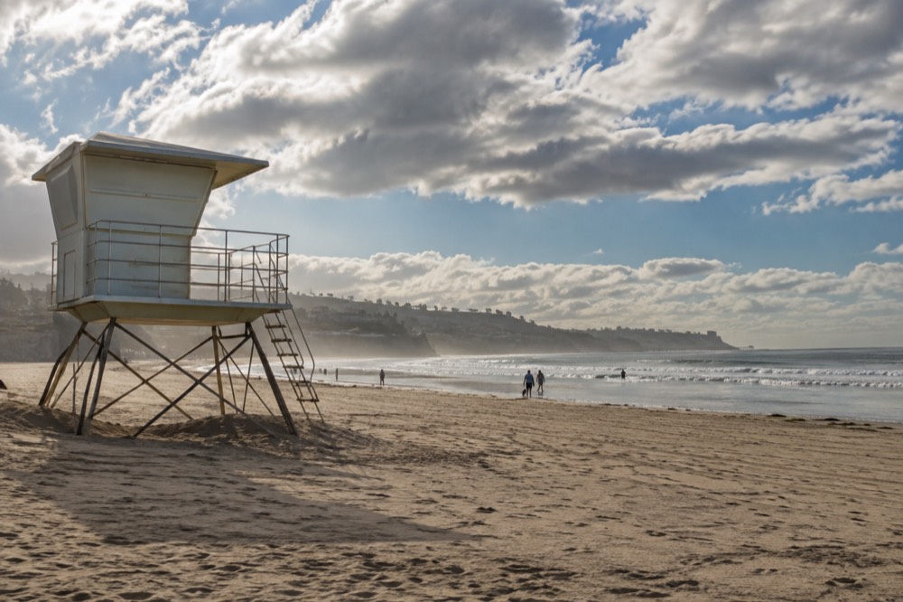 A lifeguard tower above a wide sandy beach in morning light