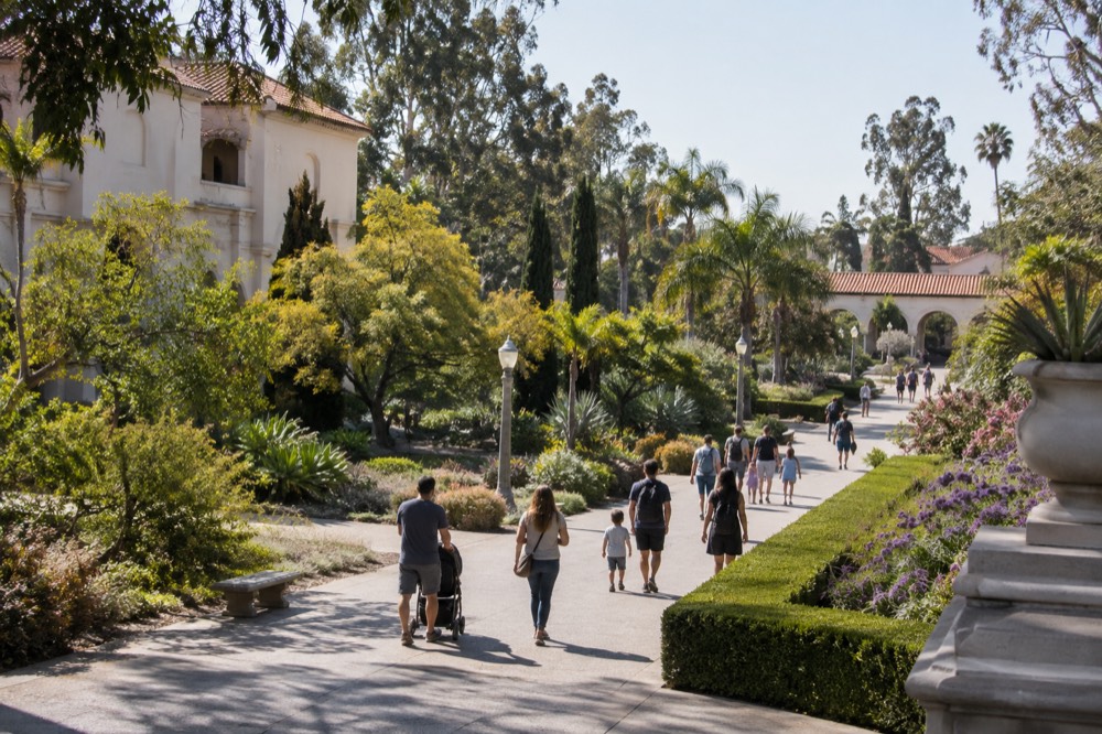 Families walking a wide path through Balboa Park gardens on a sunny afternoon