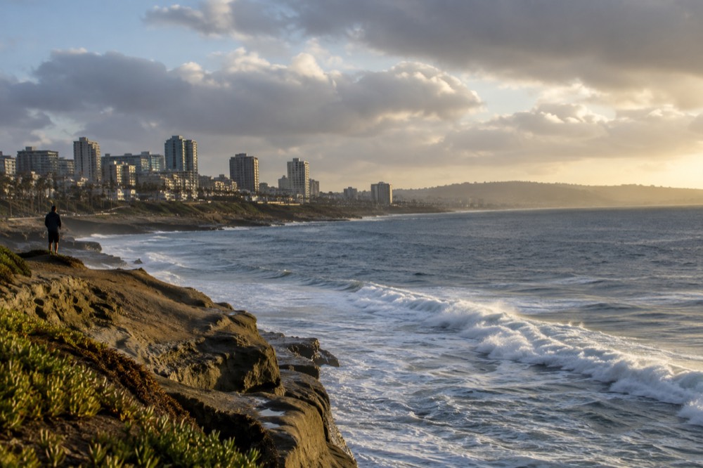 Empty coastal overlook with waves breaking below in warm late-afternoon light