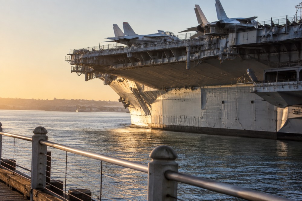 Aircraft carrier flight deck with restored jet aircraft along San Diego Bay
