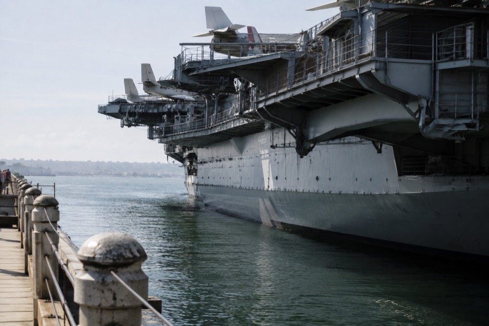 A retired aircraft carrier museum ship moored at a downtown waterfront